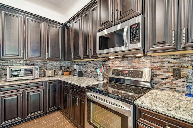 21627 Pearl Crescent Ct, Land O Lakes, FL 34637 - kitchen with light stone countertops, dark brown cabinetry, stainless steel appliances, decorative backsplash, and a toaster