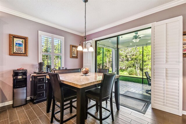 21627 Pearl Crescent Ct, Land O Lakes, FL 34637 - dining room with crown molding, baseboards, a ceiling fan, and dark wood-style flooring