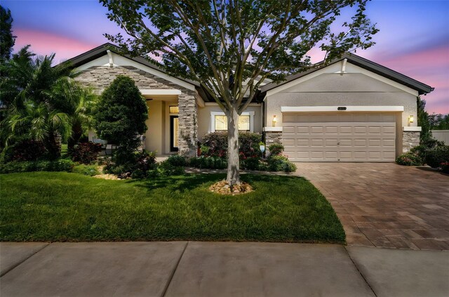 21627 Pearl Crescent Ct, Land O Lakes, FL 34637 - view of front of house with an attached garage, driveway, stucco siding, and stone siding