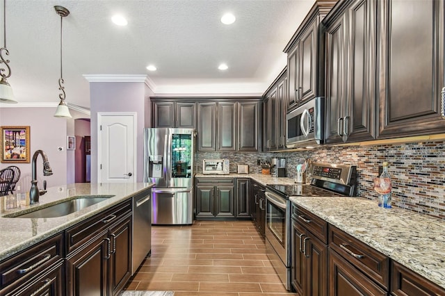 21627 Pearl Crescent Ct, Land O Lakes, FL 34637 - kitchen featuring a sink, a textured ceiling, stainless steel appliances, decorative backsplash, and light stone counters