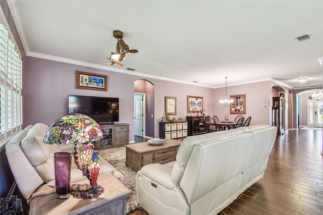 21627 Pearl Crescent Ct, Land O Lakes, FL 34637 - living area featuring an inviting chandelier, crown molding, dark wood-type flooring, visible vents, and arched walkways