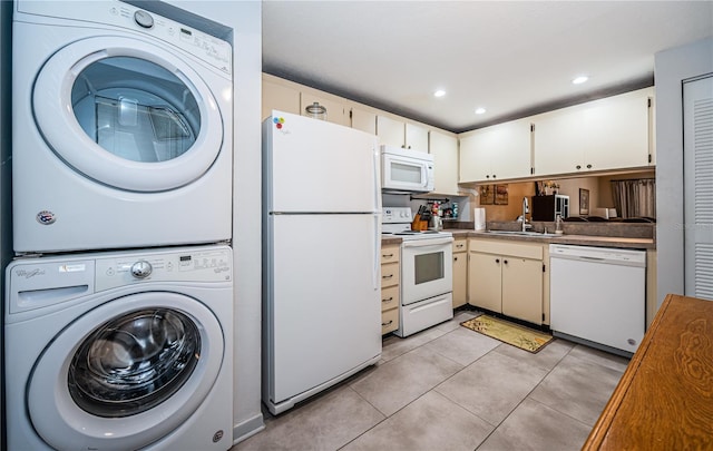 kitchen with a sink, stacked washer / dryer, recessed lighting, white appliances, and light tile patterned floors