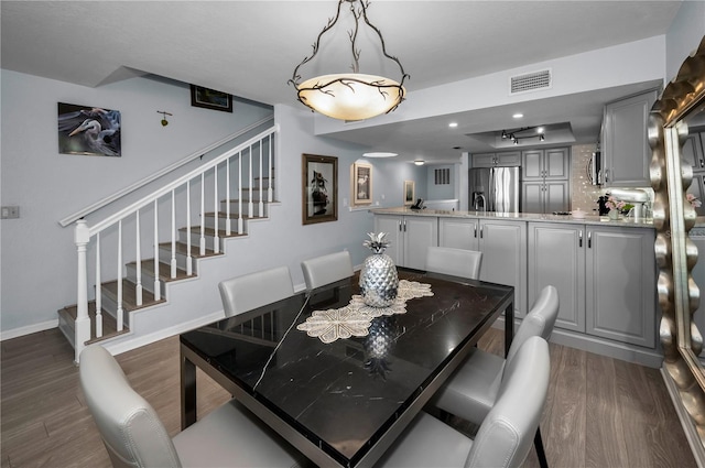 14723 Seminole Trl, Seminole, FL 33776 - dining space featuring stairs, baseboards, visible vents, and dark wood-type flooring