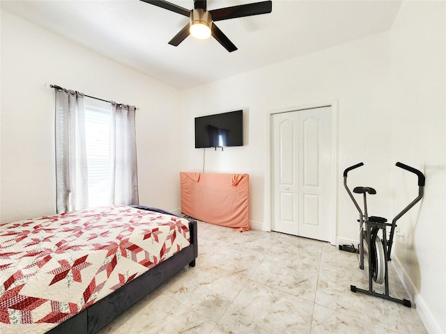 bedroom with a closet, ceiling fan, and baseboards