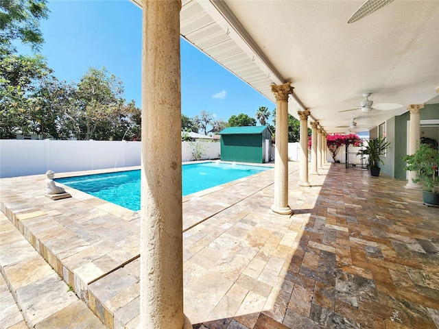 view of pool with a patio, a shed, a fenced backyard, an outbuilding, and ceiling fan