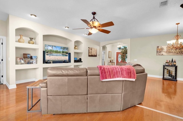 12304 Freesia Ct, Riverview, FL 33569 - living area with built in shelves, light wood finished floors, arched walkways, and baseboards