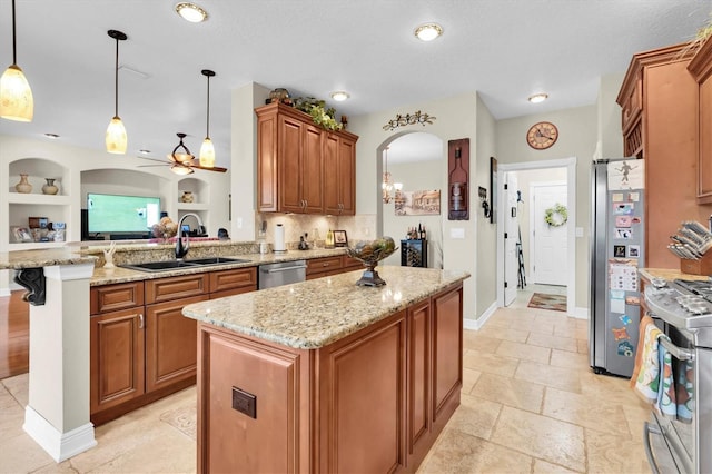 12304 Freesia Ct, Riverview, FL 33569 - kitchen featuring a peninsula, a center island, brown cabinetry, appliances with stainless steel finishes, and a sink