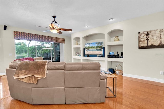 12304 Freesia Ct, Riverview, FL 33569 - living room with built in features, ceiling fan, wood finished floors, and baseboards