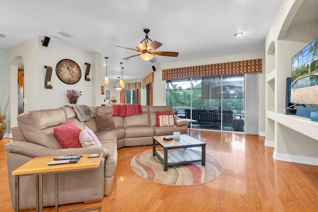 12304 Freesia Ct, Riverview, FL 33569 - living room featuring arched walkways, a ceiling fan, visible vents, wood finished floors, and baseboards