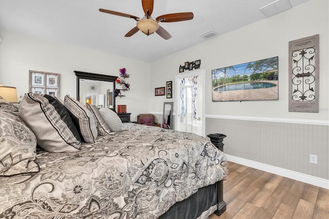 12304 Freesia Ct, Riverview, FL 33569 - bedroom featuring wood finished floors, a ceiling fan, visible vents, and a wainscoted wall