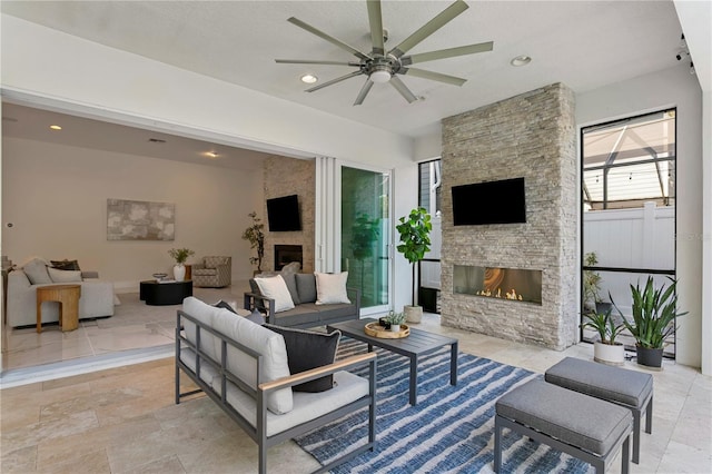 living room with a ceiling fan, an outdoor stone fireplace, and recessed lighting