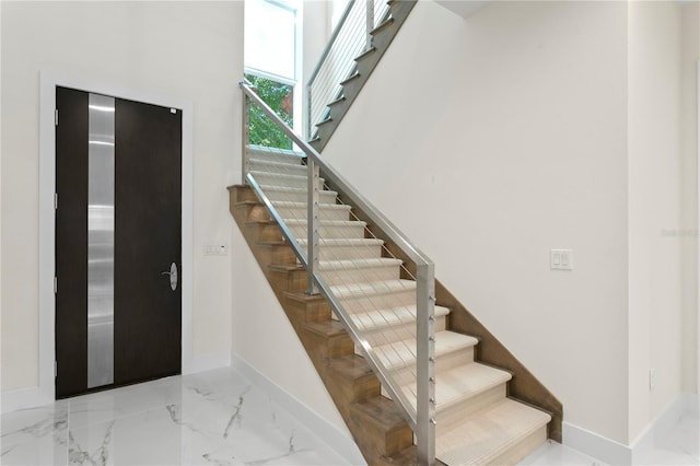 stairs with baseboards and marble finish floor