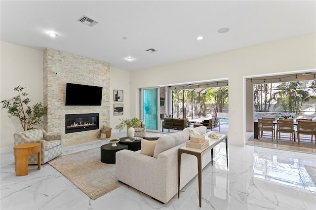 living area featuring marble finish floor, visible vents, recessed lighting, and a fireplace