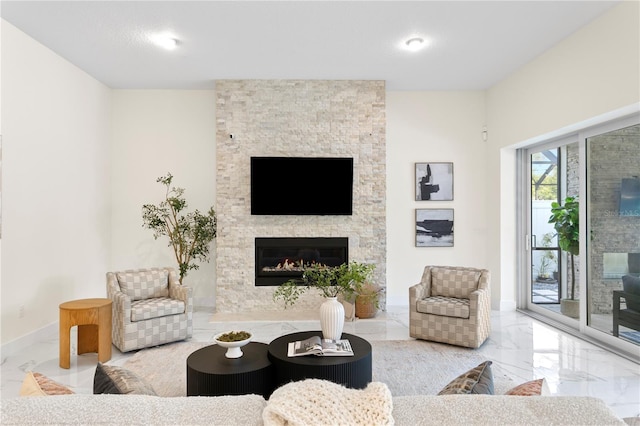 living area with marble finish floor, baseboards, and a fireplace