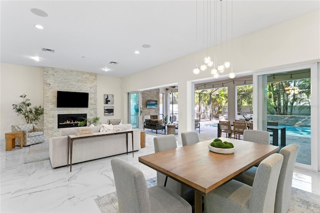 dining area featuring marble finish floor, a fireplace, visible vents, and recessed lighting