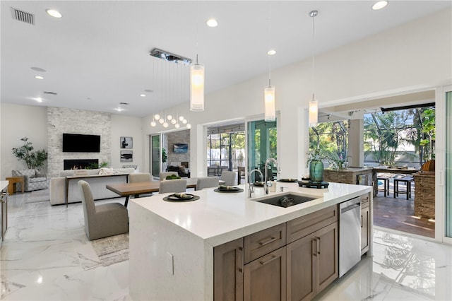kitchen with visible vents, dishwasher, marble finish floor, a sink, and an island with sink