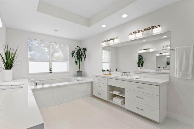 bathroom featuring a bath, recessed lighting, vanity, and a raised ceiling