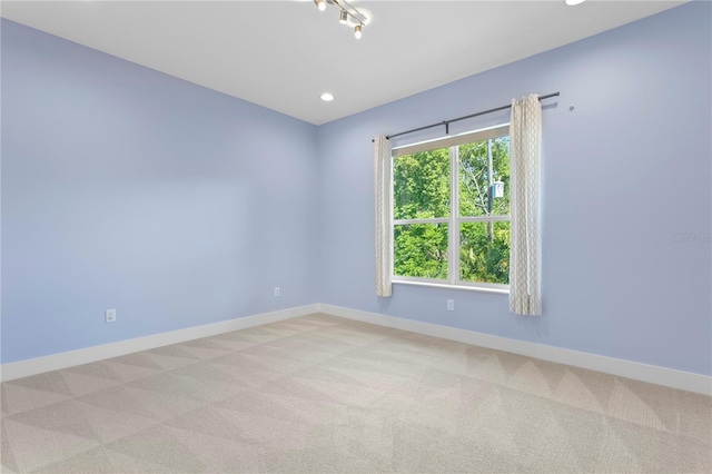 empty room with light carpet, baseboards, and recessed lighting