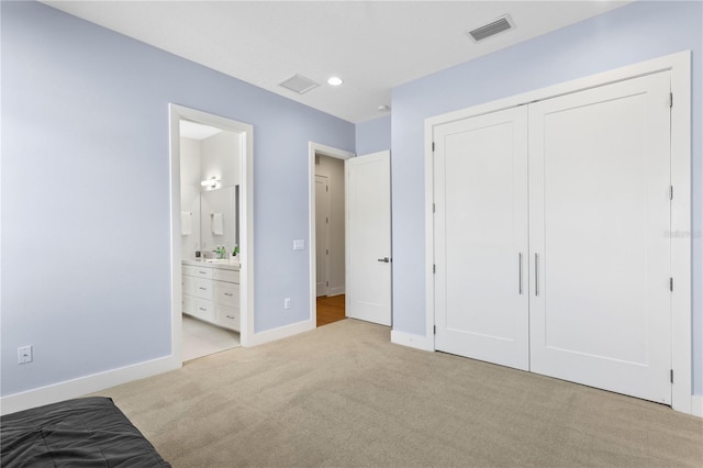 unfurnished bedroom featuring baseboards, connected bathroom, visible vents, light carpet, and a closet