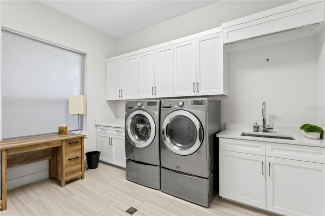 laundry room with a sink, cabinet space, and washer and dryer