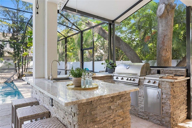 view of patio / terrace with a sink, area for grilling, a lanai, and a grill