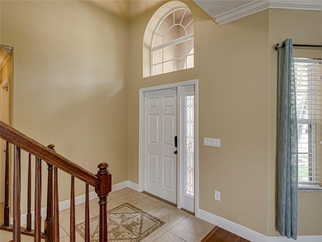 entrance foyer with baseboards, light tile patterned flooring, and stairs