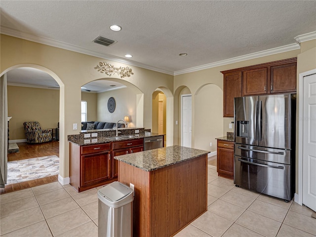 kitchen with a sink, visible vents, appliances with stainless steel finishes, and light tile patterned floors