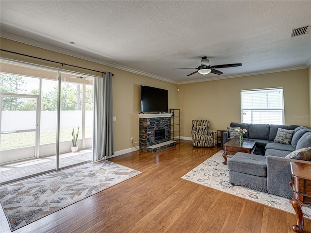 living area featuring ceiling fan, wood finished floors, and a healthy amount of sunlight