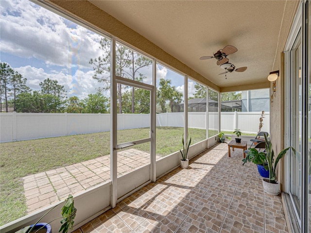 sunroom featuring a healthy amount of sunlight and a ceiling fan