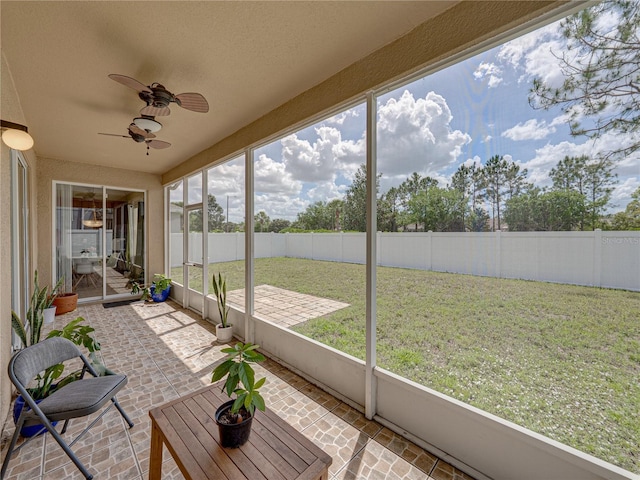 unfurnished sunroom featuring a ceiling fan