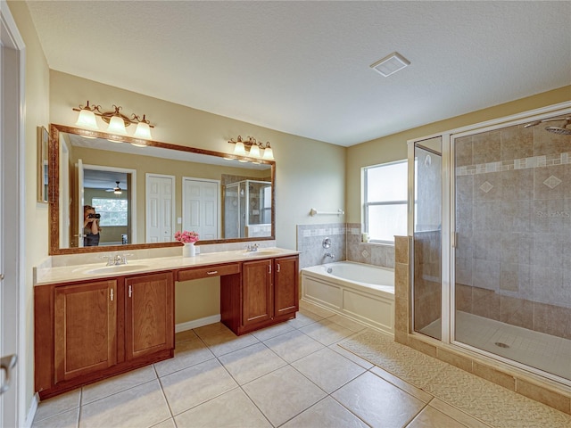 bathroom featuring tile patterned floors, a bath, a sink, and a stall shower