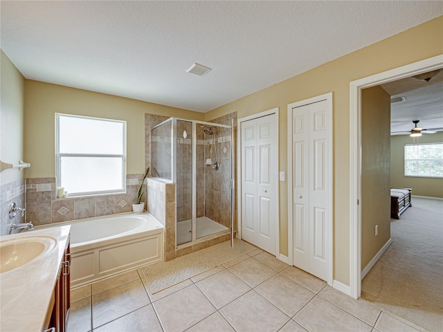 full bath featuring a shower stall, tile patterned floors, a bath, and a textured ceiling