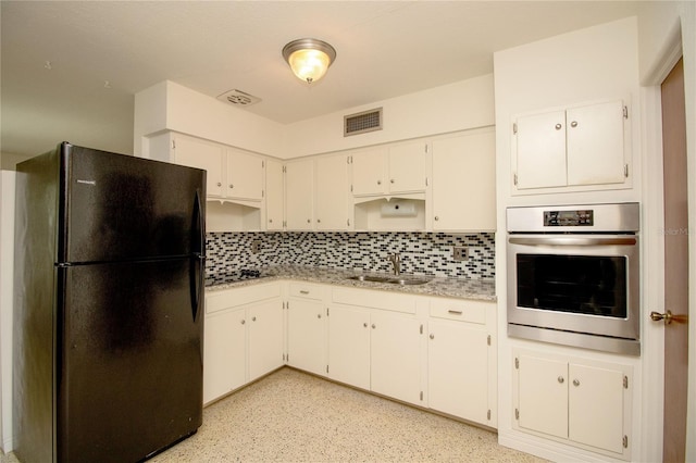 721 75th Ave N, Saint Petersburg, FL 33702 - kitchen with freestanding refrigerator, backsplash, visible vents, stainless steel oven, and a sink
