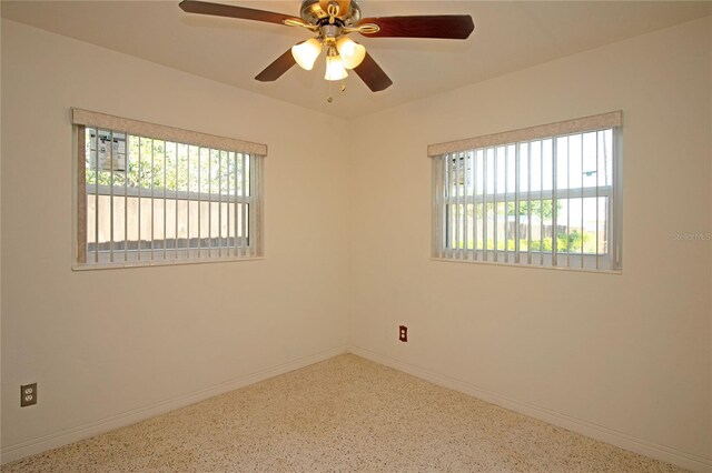 721 75th Ave N, Saint Petersburg, FL 33702 - spare room with speckled floor, baseboards, plenty of natural light, and ceiling fan