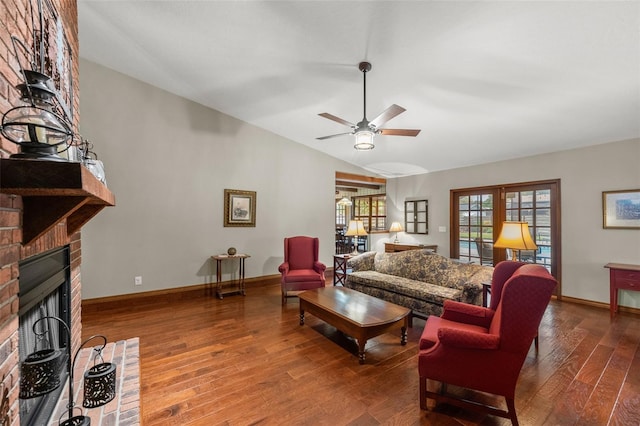 living area featuring baseboards, a brick fireplace, ceiling fan, vaulted ceiling, and wood-type flooring