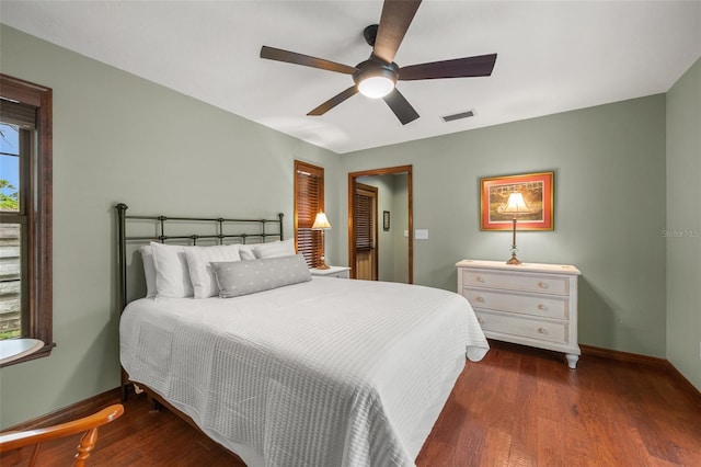 bedroom with visible vents, baseboards, a ceiling fan, and wood finished floors
