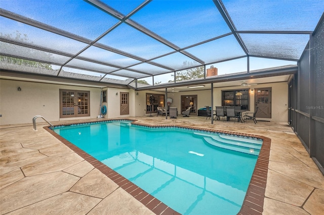pool featuring french doors, a patio area, a ceiling fan, and glass enclosure