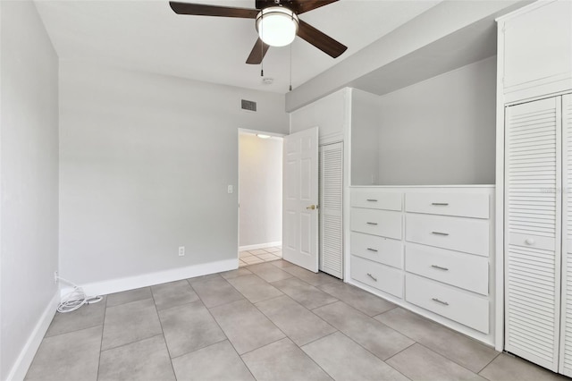 unfurnished bedroom with light tile patterned floors, baseboards, a ceiling fan, and visible vents