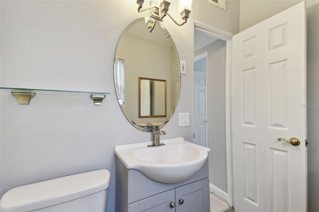 half bath featuring vanity and toilet
