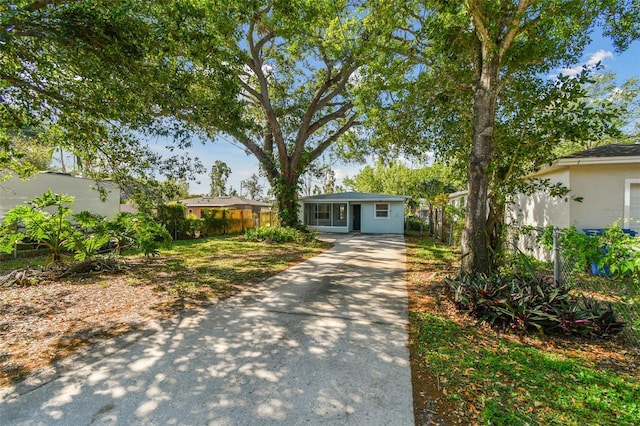 view of front of home featuring concrete driveway, stucco siding, and fence