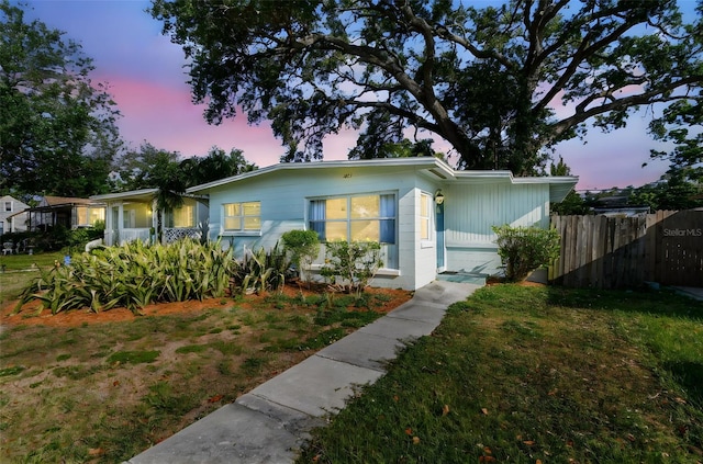 view of front of house featuring fence and a front lawn