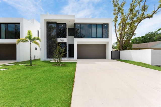 7608 Antilla St, Tampa, FL 33625 - modern home featuring a front yard, driveway, stucco siding, and fence
