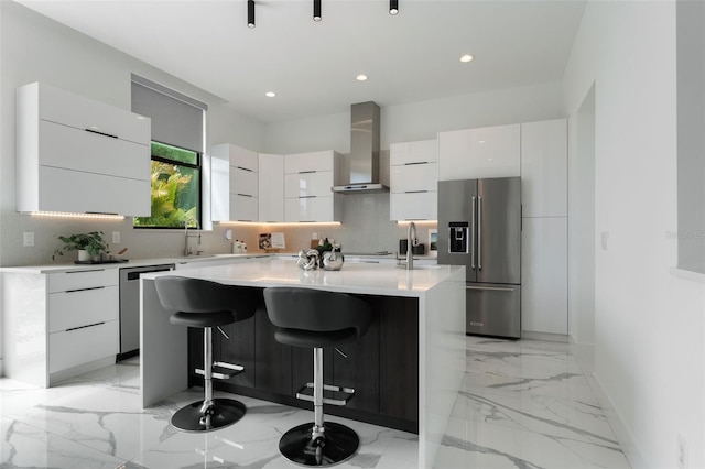 7608 Antilla St, Tampa, FL 33625 - kitchen featuring modern cabinets, wall chimney exhaust hood, a center island with sink, appliances with stainless steel finishes, and backsplash