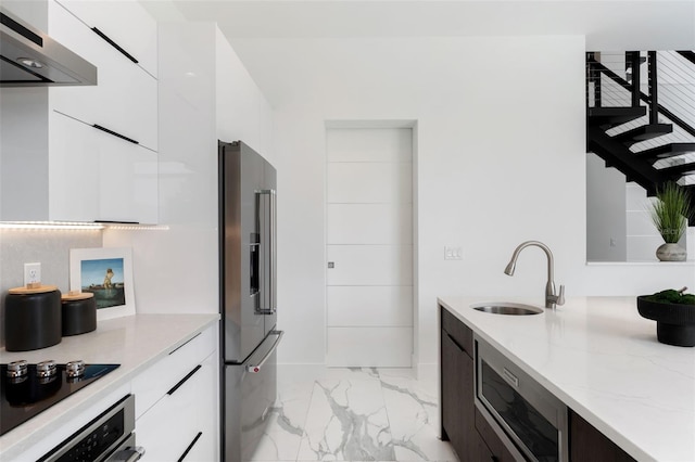 7608 Antilla St, Tampa, FL 33625 - kitchen featuring under cabinet range hood, a sink, white cabinets, modern cabinets, and appliances with stainless steel finishes