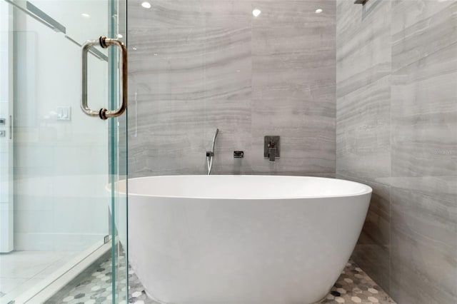 7608 Antilla St, Tampa, FL 33625 - bathroom featuring a freestanding tub, a stall shower, and tile walls