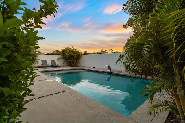 7608 Antilla St, Tampa, FL 33625 - pool at dusk featuring an outdoor pool, fence, and a patio