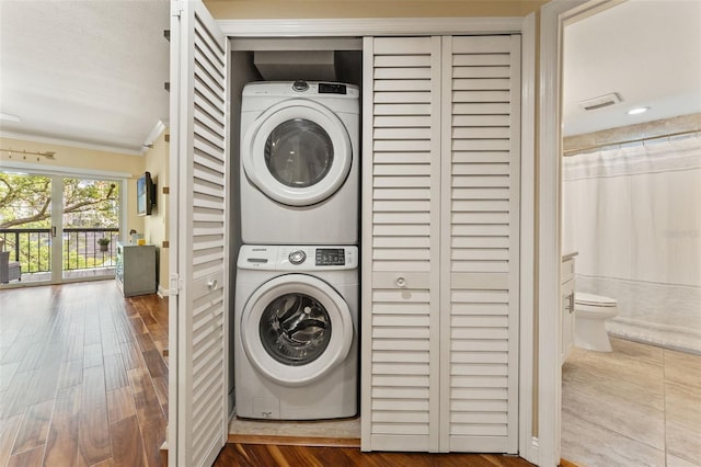 1002 S Harbour Island Blvd Unit 1312, Tampa, FL 33602 - laundry room with crown molding, wood finished floors, stacked washer and clothes dryer, laundry area, and visible vents