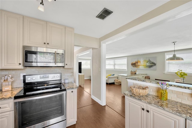 5367 5th Ave N, Saint Petersburg, FL 33710 - kitchen with decorative backsplash, dark wood-style flooring, visible vents, and stainless steel appliances