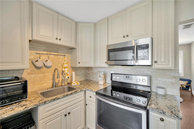 5367 5th Ave N, Saint Petersburg, FL 33710 - kitchen with decorative backsplash, visible vents, a toaster, stainless steel appliances, and a sink