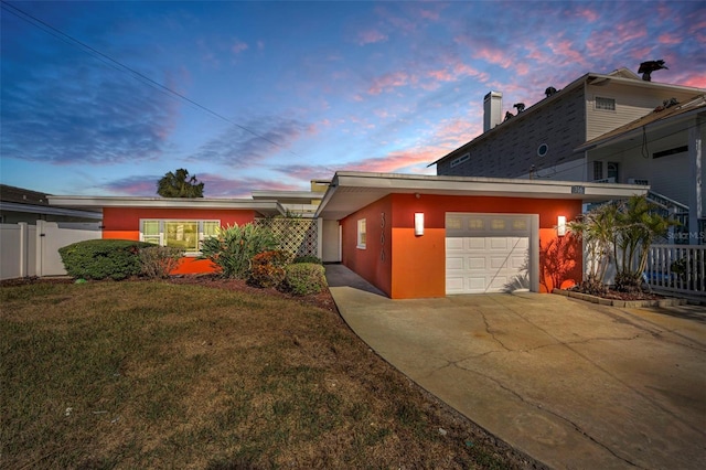 366 La Hacienda Dr, Indian Rocks Beach, FL 33785 - view of home's exterior featuring a garage, fence, driveway, stucco siding, and a yard